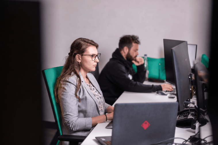 Twee SELAS-medewerkers werken geconcentreerd aan hun computer